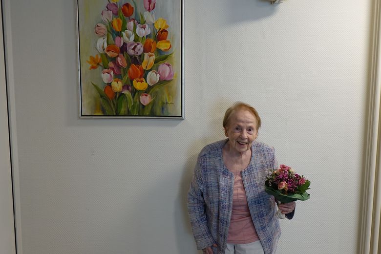 Das Bild zeigt Frau Antje Gruben mit Blumenstrauß im Foyer des Hauses zur Übergabe des gespendeten Bildes 